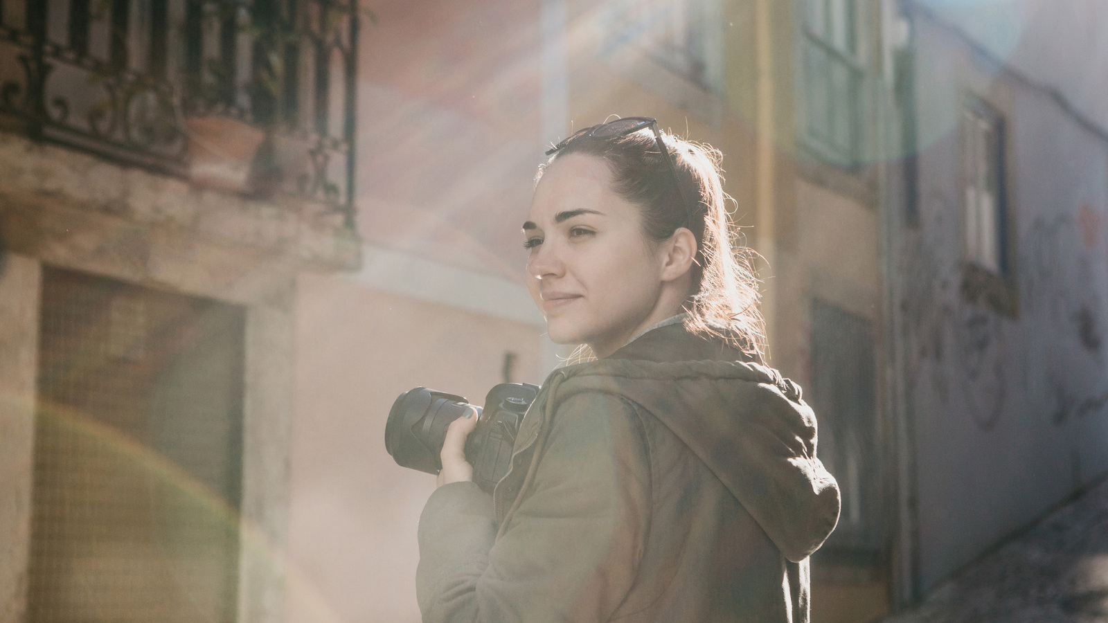 A street photographer or a young woman takes pictures of authentic houses in Lisbon in Portugal. A professional photographer or tourist taking pictures for memory A mennyiség helyett a minőségre koncentrálj! - NEXTFOTO